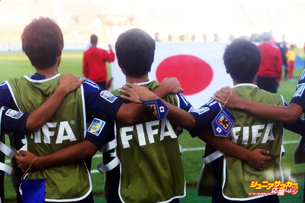SHARJAH, UNITED ARAB EMIRATES - OCTOBER 28:  Substitution players of Japan sing their national anthem prior to the FIFA U-17 World Cup UAE 2013 Round of 16 match between Japan and Sweden at Sharjah Stadium on October 28, 2013 in Sharjah, United Arab Emirates.  (Photo by Alex Grimm - FIFA/FIFA via Getty Images)